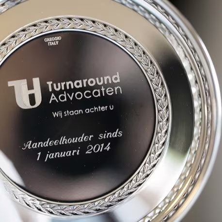 Verzilverde flessenbak met een bedrijfslogo en bedank tekst.