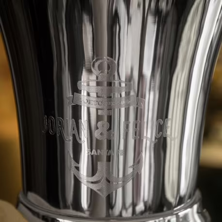 Gegraveerd logo op een verzilverde wijnkoeler.