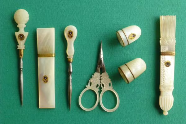 Naaigerei van parelmoer met goud en een viooltje